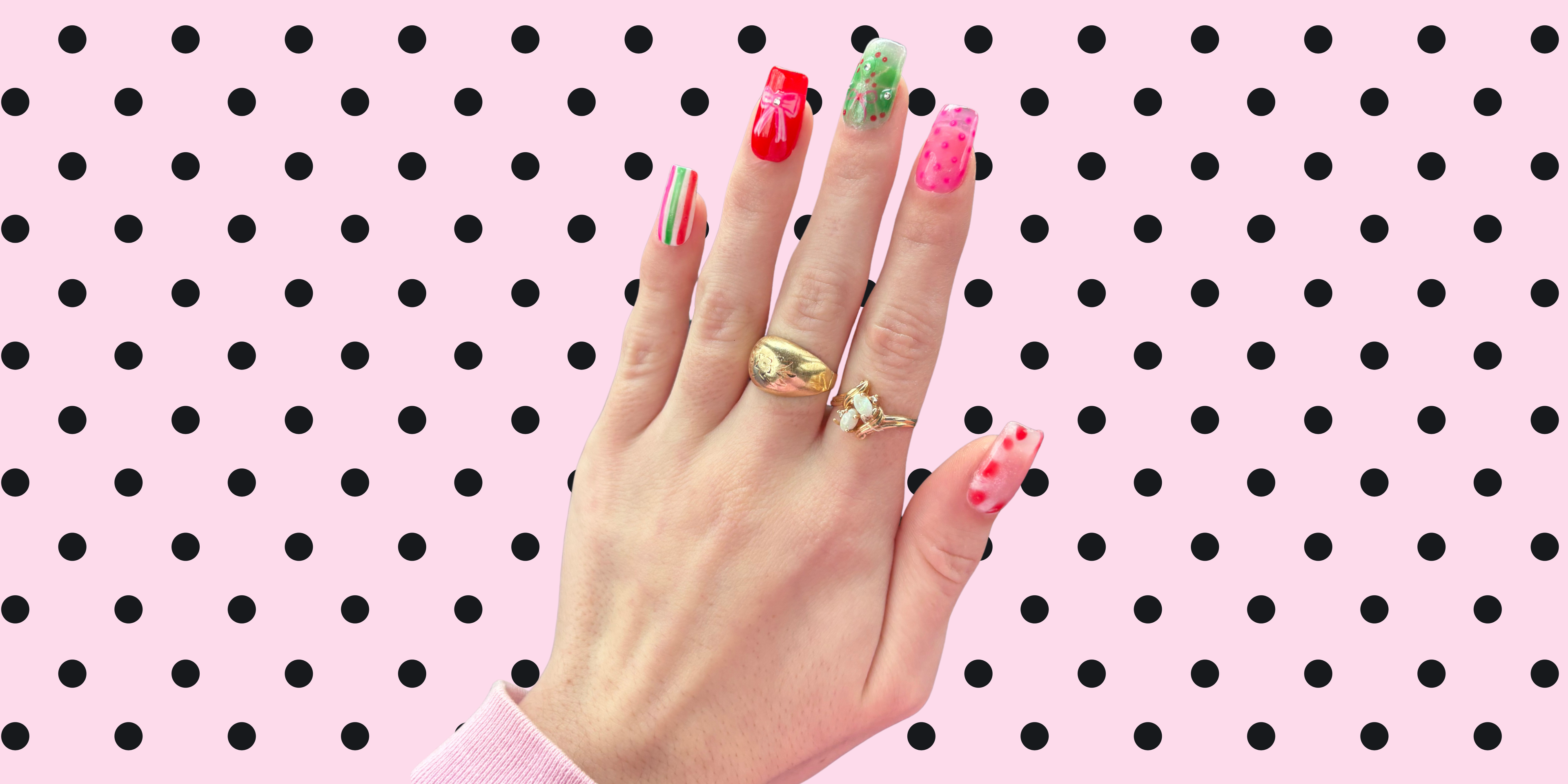 Hand with colorful nails and rings on a polka dot background